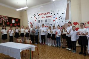 Uczniowie wykonują utwór z towarzyszeniem grzechotek i tamburynów.